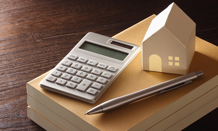 家の模型と電卓と筆記用具