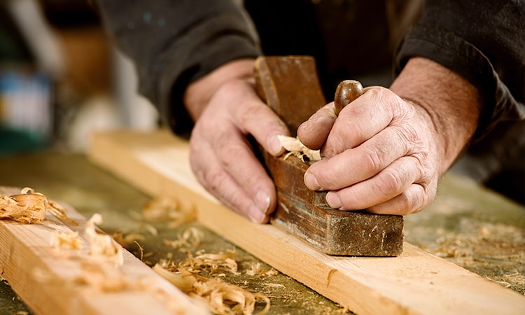 かんなで木材を削る職人の手
